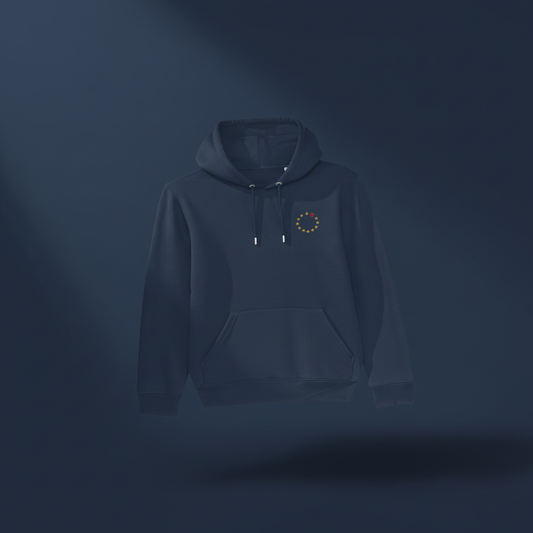A dark navy blue pullover hoodie with a small circular multicolor graphic on the left chest, displayed against a dark navy background with a soft spotlight effect.